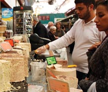 At the Jerusalem outdoor market, a vendor cuts samples of halvah. // © 2011 Mindy Poder
