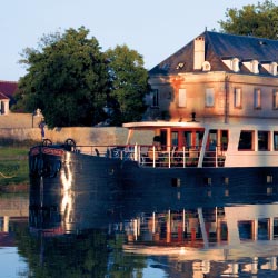 Clients can enjoy the scenery from the barge’s open-air deck. // © 2013 French Country Waterways