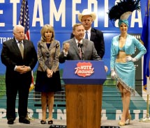 From left to right: Roger Dow, Kristin KcMillan and Tom Collins join Rossi Ralenkotter (at podium) and a Vegas showgirl during the first stop of the Vote Travel bus tour. // © 2012